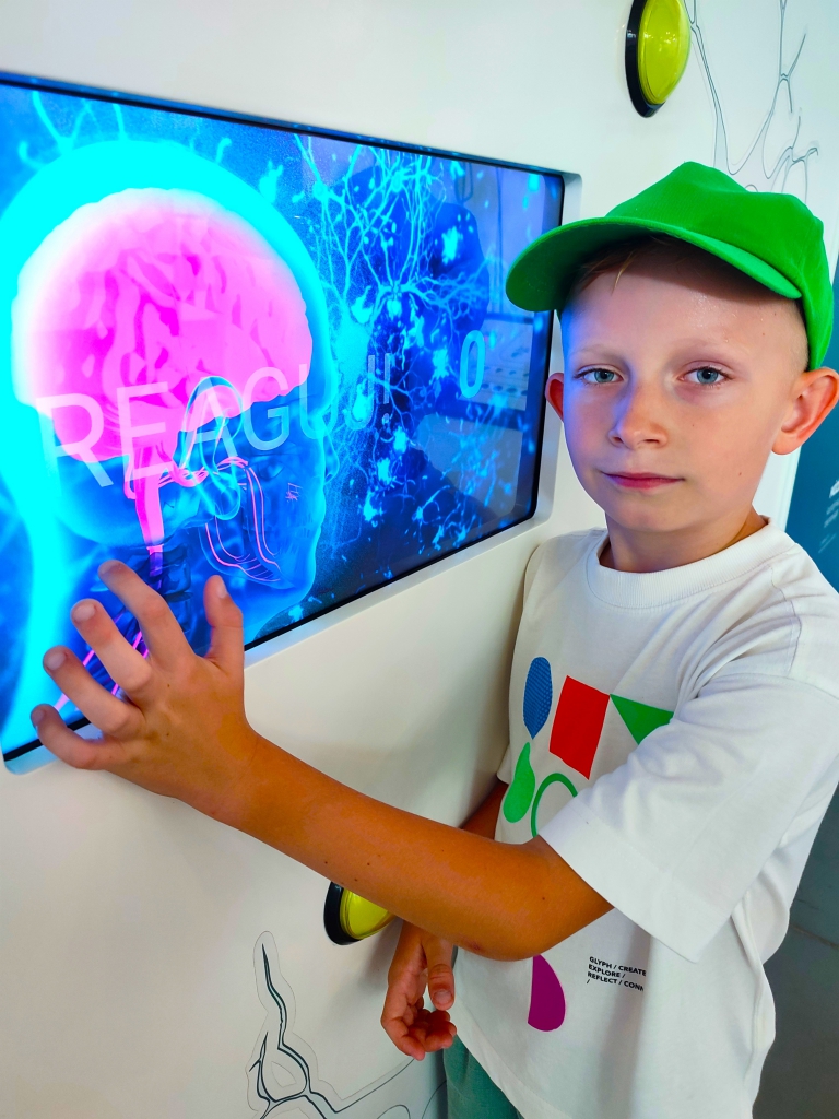 Chłopiec przy wystawie multimedialnej