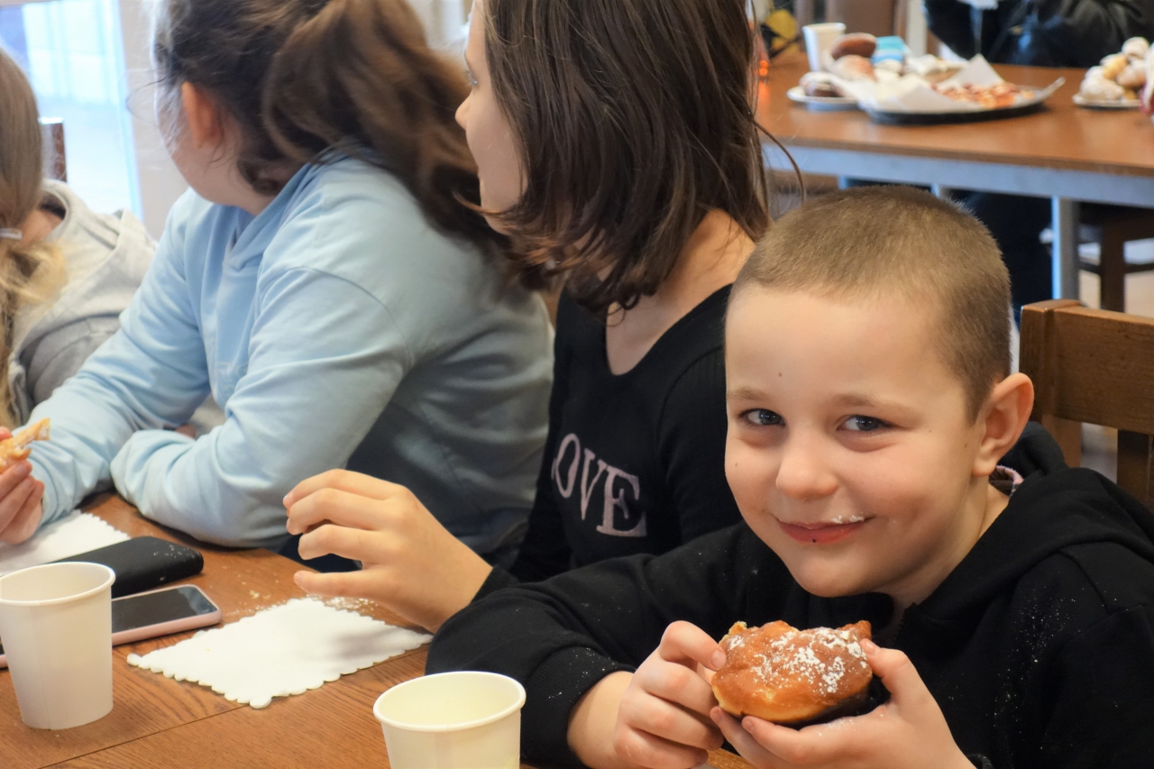 Dzieci jedzą pączki